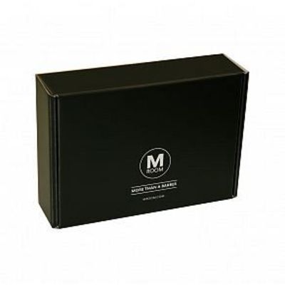 Musta pahvilaatikko lahjalaatikko jossa on M Room logo ja slogan More than a barber